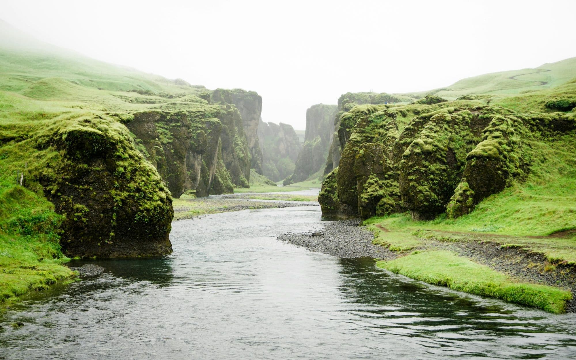 A calm river running between mossy green cliffs