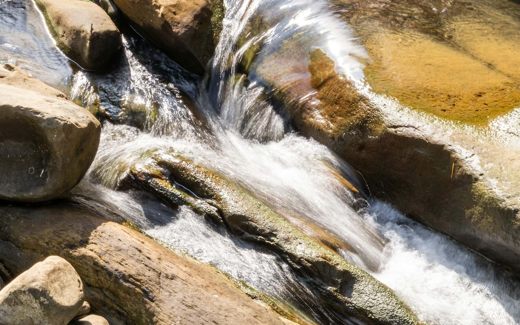 Water flowing around smooth, weathered river stones