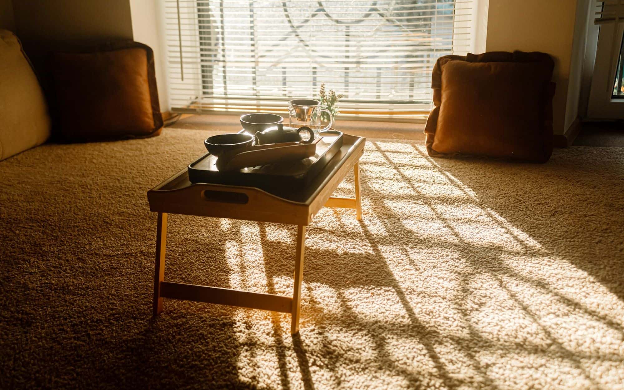 Late sunlight falling across a quiet room with a low table