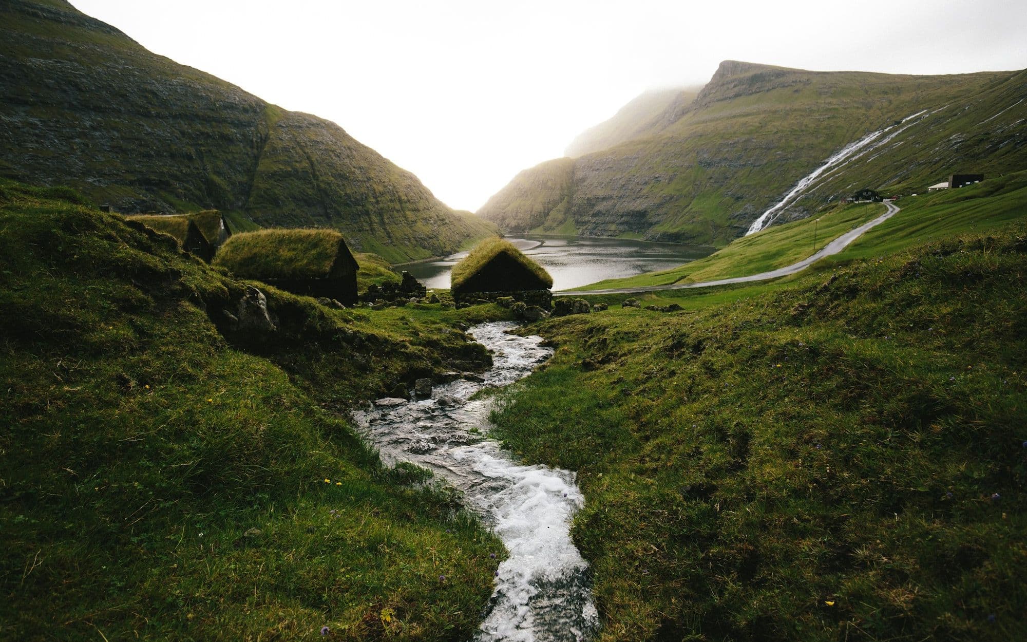 A stream winding down through misty green hills