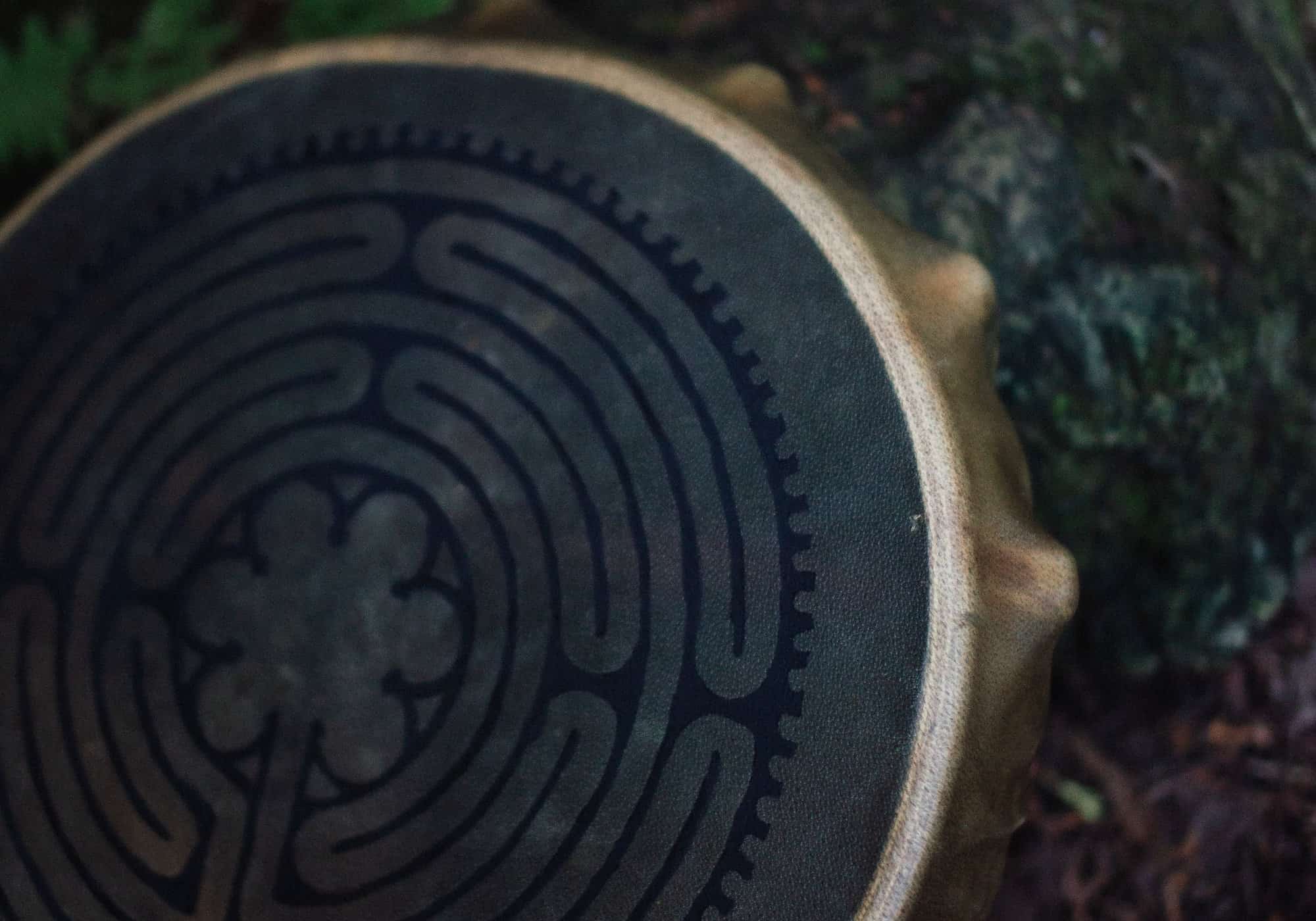 Close view of a hand drum painted with a labyrinth pattern