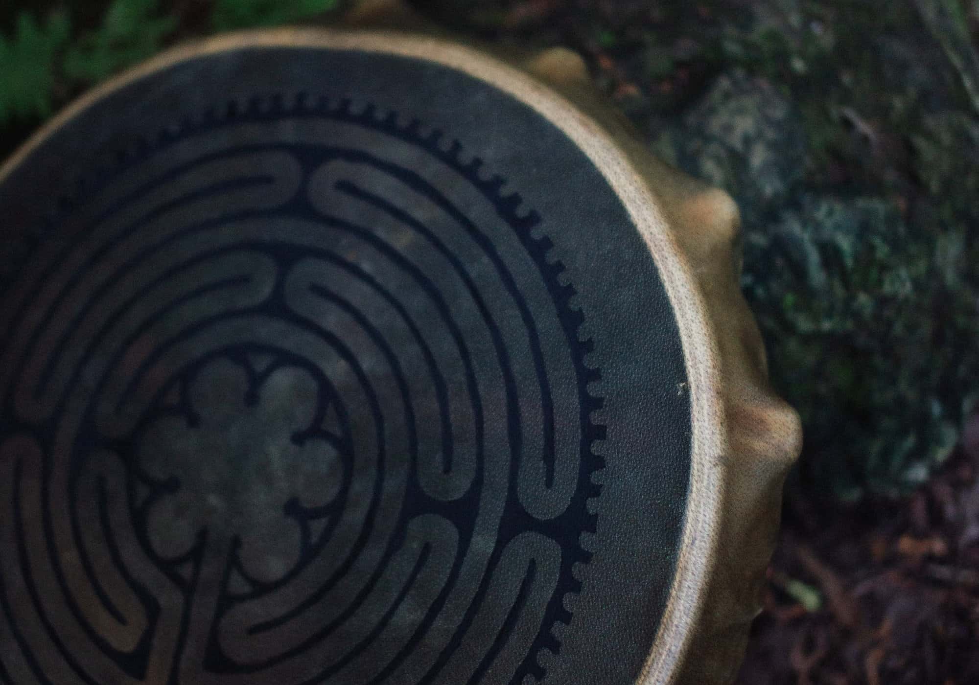 Close view of a hand drum painted with a labyrinth pattern
